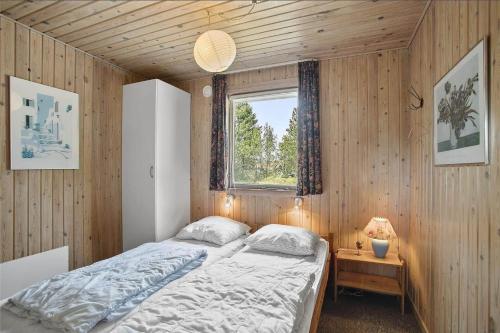 a bedroom with a bed in a wooden wall at JB102-Fjerritslev-Blabaerstien-7 in Fjerritslev
