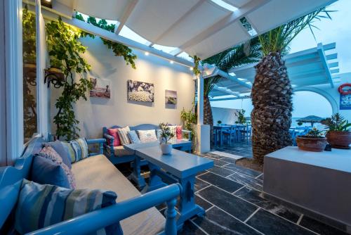 a patio with couches and tables and plants at Sigalas Beach Hotel in Kamari