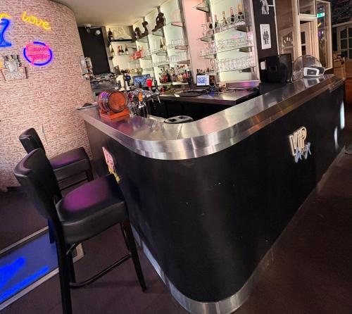 a bar in a restaurant with a counter and a chair at Hôtel Garden's jacuzzi spa 1 in Brussels