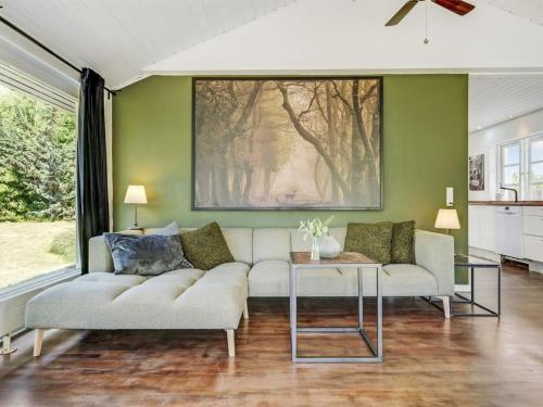 a living room with a couch and a painting on the wall at Holiday Home Øllegaard - 1km from the sea by Interhome in Dronningmølle