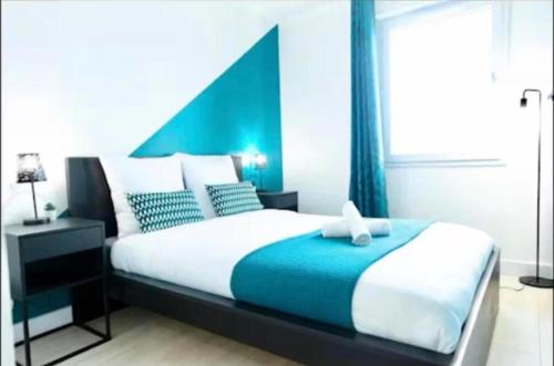 a bedroom with a large bed with a blue headboard at Modern Blue - Disneyland Paris in Magny-le-Hongre