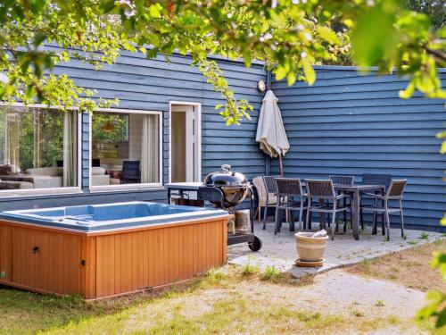 a hot tub in the backyard of a blue house at Holiday Home Hannelore - 700m from the sea by Interhome in Nykøbing Sjælland