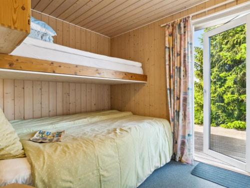 a bedroom with a bunk bed and a window at Holiday Home Eleana - 300m to the fjord by Interhome in Roskilde