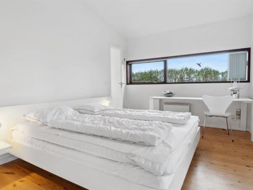two beds in a white bedroom with a window at Holiday Home Erikka - 300m to the inlet by Interhome in Holbæk