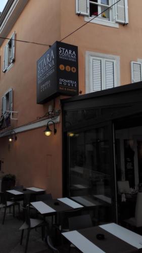 a restaurant with tables and signs on the side of a building at Bed and Brekfast Donatella in Piran
