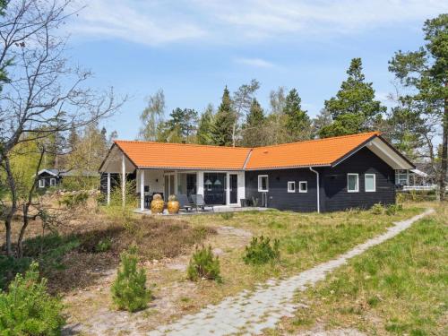 a house with an orange roof in a field at Holiday Home Rikkie - 150m to the fjord by Interhome in Rørvig