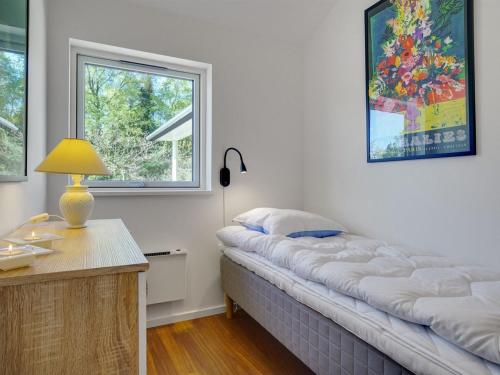 a room with a bed and a desk with a lamp at Holiday Home Rikkie - 150m to the fjord by Interhome in Rørvig
