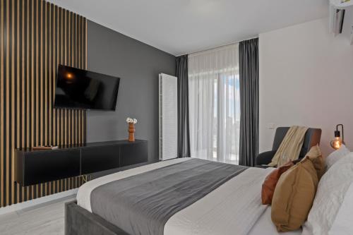een slaapkamer met een bed en een tv aan de muur bij Terracotta Oasis in Boekarest