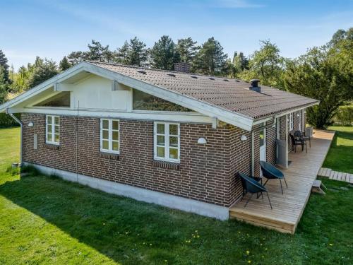 DronningmølleにあるHoliday Home Melle - 350m from the sea by Interhomeの木製のデッキ付きの小さな赤レンガ造りの家