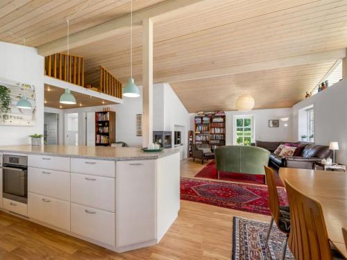 een keuken met witte kasten en een woonkamer bij Holiday Home Melle - 350m from the sea by Interhome in Dronningmølle