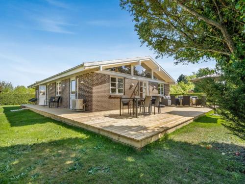 een klein bakstenen huis met een houten terras bij Holiday Home Melle - 350m from the sea by Interhome in Dronningmølle