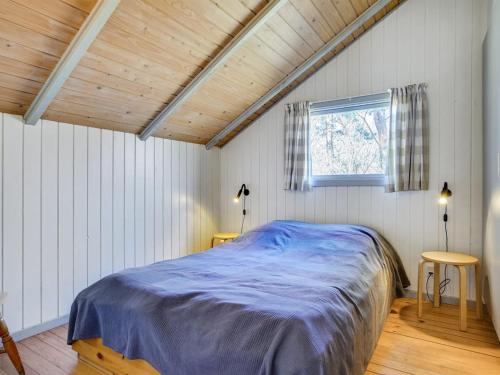 a bedroom with a blue bed in a room with a window at Holiday Home Erly - 500m from the sea by Interhome in Nykøbing Sjælland