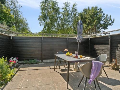 a patio with a table and an umbrella at Holiday Home Ludvika - 350m from the sea by Interhome in Tjørneholm