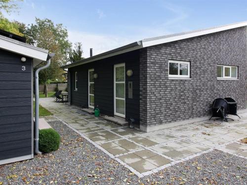 una casa negra con un patio delante en Holiday Home Bjerne - 200m from the sea by Interhome, en Rødvig