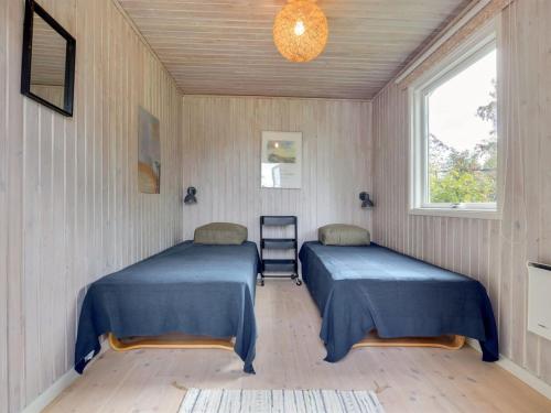 a room with two beds and a window at Holiday Home Gærmund - 350m from the sea by Interhome in Føllenslev