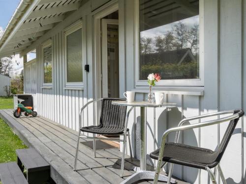a patio with two chairs and a table on a porch at Holiday Home Erva - 495m from the sea by Interhome in Gedser