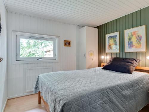 a bedroom with a bed and a window at Holiday Home Maiken - 1-5km from the sea by Interhome in Føllenslev