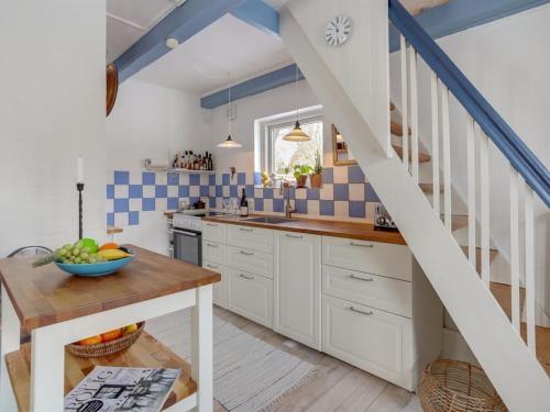 a kitchen with white cabinets and a blue and white staircase at Holiday Home Eeli - 150m from the sea by Interhome in Fakse Ladeplads