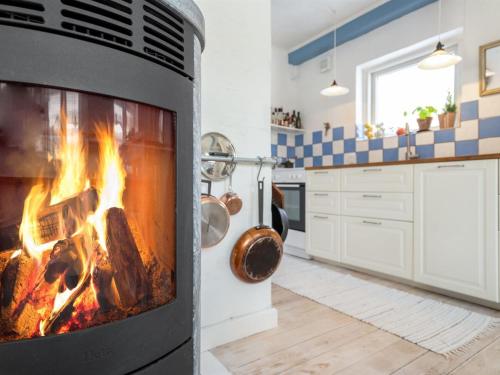 a kitchen with a fireplace in a kitchen at Holiday Home Eeli - 150m from the sea by Interhome in Fakse Ladeplads