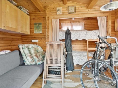 a bedroom with a couch and a bike in a cabin at Holiday Home Sander - 800m from the sea by Interhome in Højby