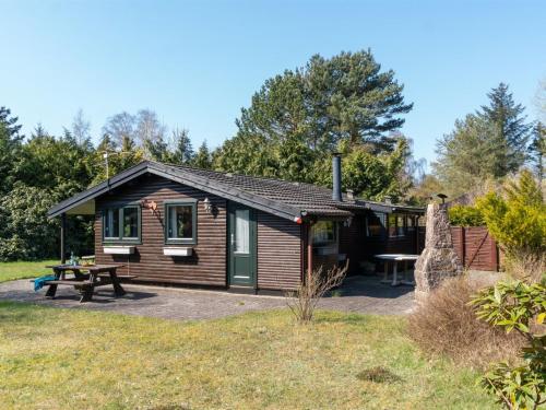 a log cabin with a picnic table and a picnic bench at Holiday Home Sander - 800m from the sea by Interhome in Højby