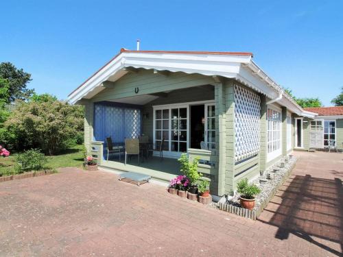 a small blue house with a porch with plants at Holiday Home Enrik - 123m from the sea by Interhome in Vordingborg