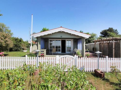 a white fence in front of a small house at Holiday Home Enrik - 123m from the sea by Interhome in Vordingborg