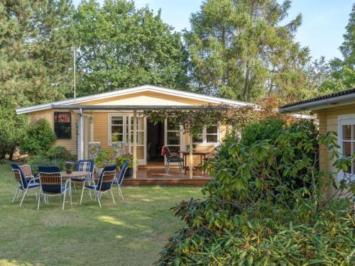 a house with a patio with chairs and a table at Holiday Home Haldis - 120m from the sea by Interhome in Stubbekøbing
