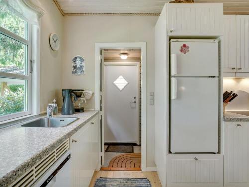 a kitchen with a sink and a refrigerator at Holiday Home Haldis - 120m from the sea by Interhome in Stubbekøbing