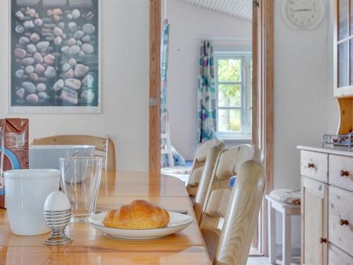 a dining room table with a plate of bread on it at Holiday Home Sini - 300m from the sea by Interhome in Gedser