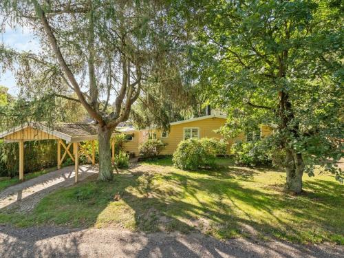 a yellow house with trees in front of it at Holiday Home Haldis - 120m from the sea by Interhome in Stubbekøbing