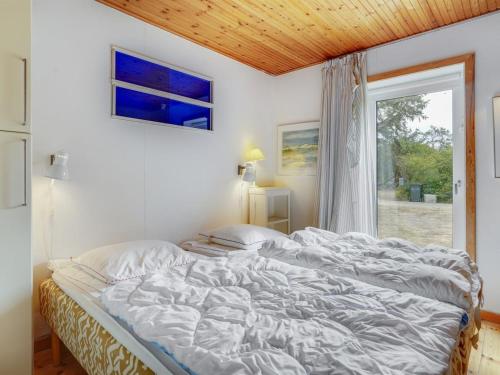 a large bed in a bedroom with a window at Holiday Home Carmen - 25m from the sea by Interhome in Lumsås