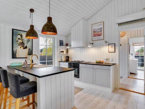 a kitchen with white cabinets and a black counter top at Holiday Home Mojsej by Interhome in Slagelse