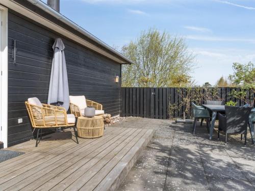 a patio with an umbrella and chairs and a table at Holiday Home Mojsej by Interhome in Slagelse