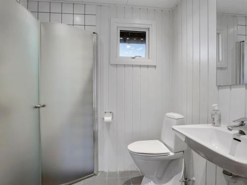 a white bathroom with a toilet and a sink at Holiday Home Esther - 700m from the sea by Interhome in Torrig