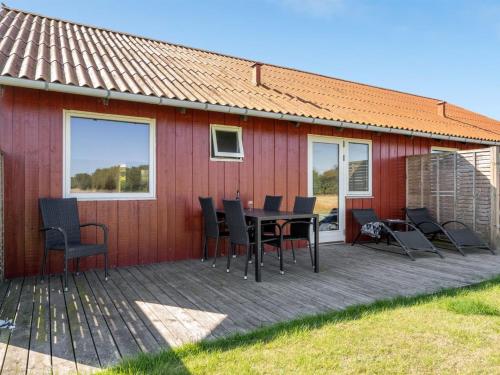a house with a wooden deck with a table and chairs at Holiday Home Esther - 700m from the sea by Interhome in Torrig
