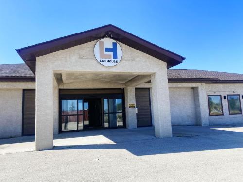 a building with a sign on the front of it at Lac House Inn in Lac du Bonnet