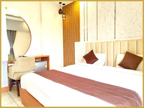 a bedroom with a bed and a mirror and a desk at Hotel Beach Gajanand Near Jagannath Temple And Sea View in Puri