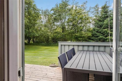 a porch with a wooden table and chairs on a patio at JB122-Fjerritslev-Tyttebaerstien-14 in Torup Strand