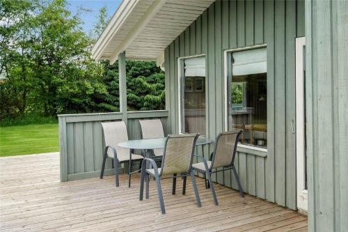 a patio with a table and chairs on a deck at JB122-Fjerritslev-Tyttebaerstien-14 in Torup Strand