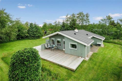 a green shed with a deck in a field at JB122-Fjerritslev-Tyttebaerstien-14 in Torup Strand