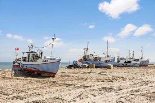three boats sitting on the sand on a beach at JB122-Fjerritslev-Tyttebaerstien-14 in Torup Strand