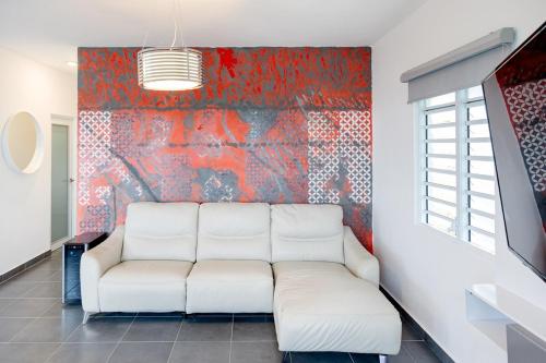 a living room with a white couch in front of a wall at Home for 10 with Pool and Solar Panels in Caguas! in Caguas