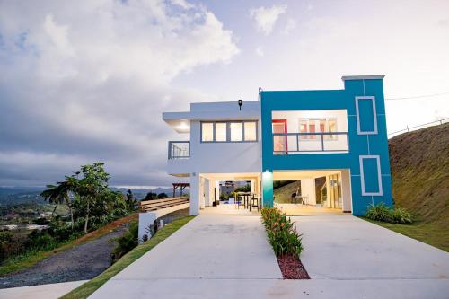 a blue and white house with a driveway at Home for 10 with Pool and Solar Panels in Caguas! in Caguas
