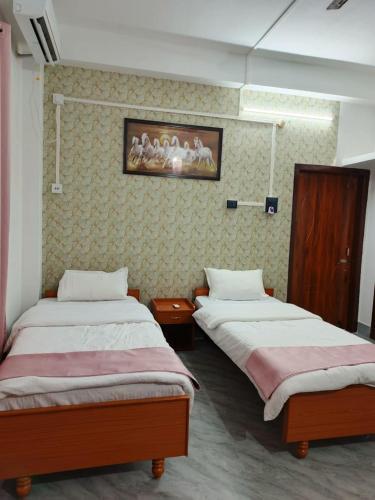 a room with two beds in a room at Rudra Homes in Lokpriya Gopinath Bordoloi International