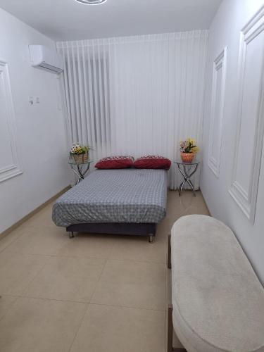 a bedroom with a bed with red pillows on it at Crown Suite in Qiryat Motzkin