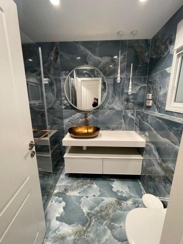 a bathroom with a sink and a mirror at Crown Suite in Qiryat Motzkin