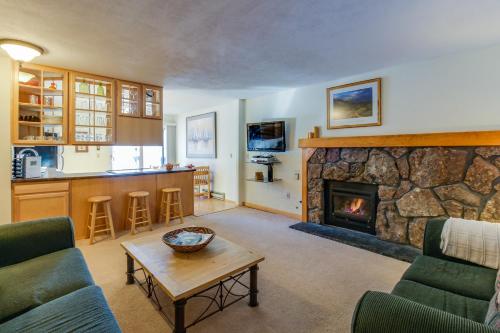 a living room with a stone fireplace and a table at Meadow Creek in Frisco