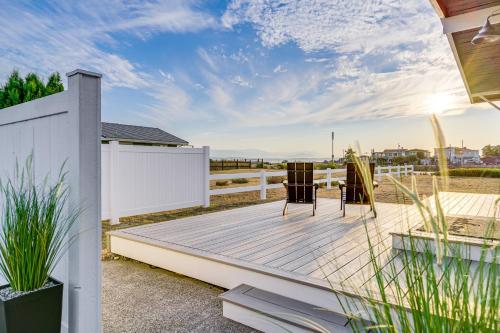 a deck with two chairs and a fence at Beach Access, Deck Waterfront Whidbey Island Home in Greenbank