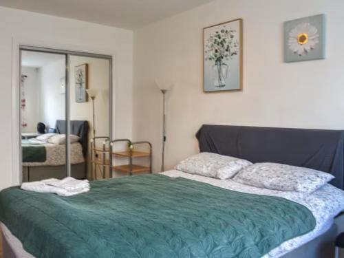 a bedroom with a bed with a green comforter at Spacious 2-Bedroom Ground Floor Flat with 2 Double Beds, Sleeps 4 in Central Aberdeen in Aberdeen